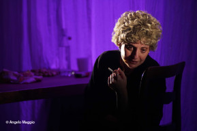 Foto di Serena Balivo, in scena seduta che si gira verso il pubblico con una sigaretta in mano.